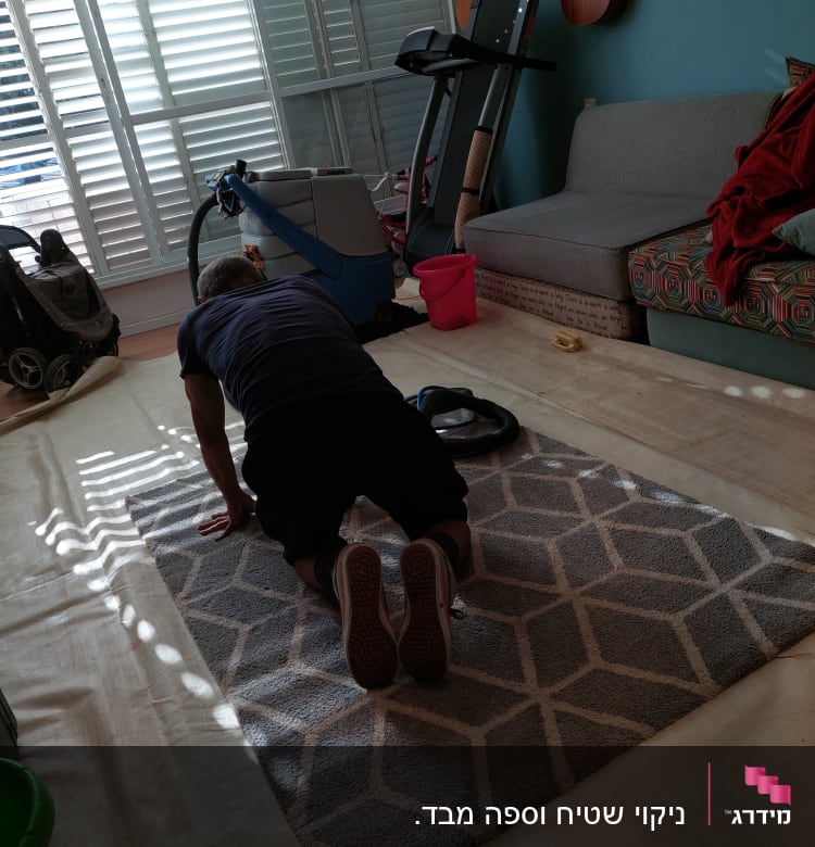 אדם מנקה שטיח עם מכונת ניקוי